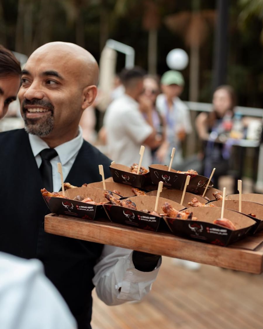 Waiter serving snacks on a wooden board