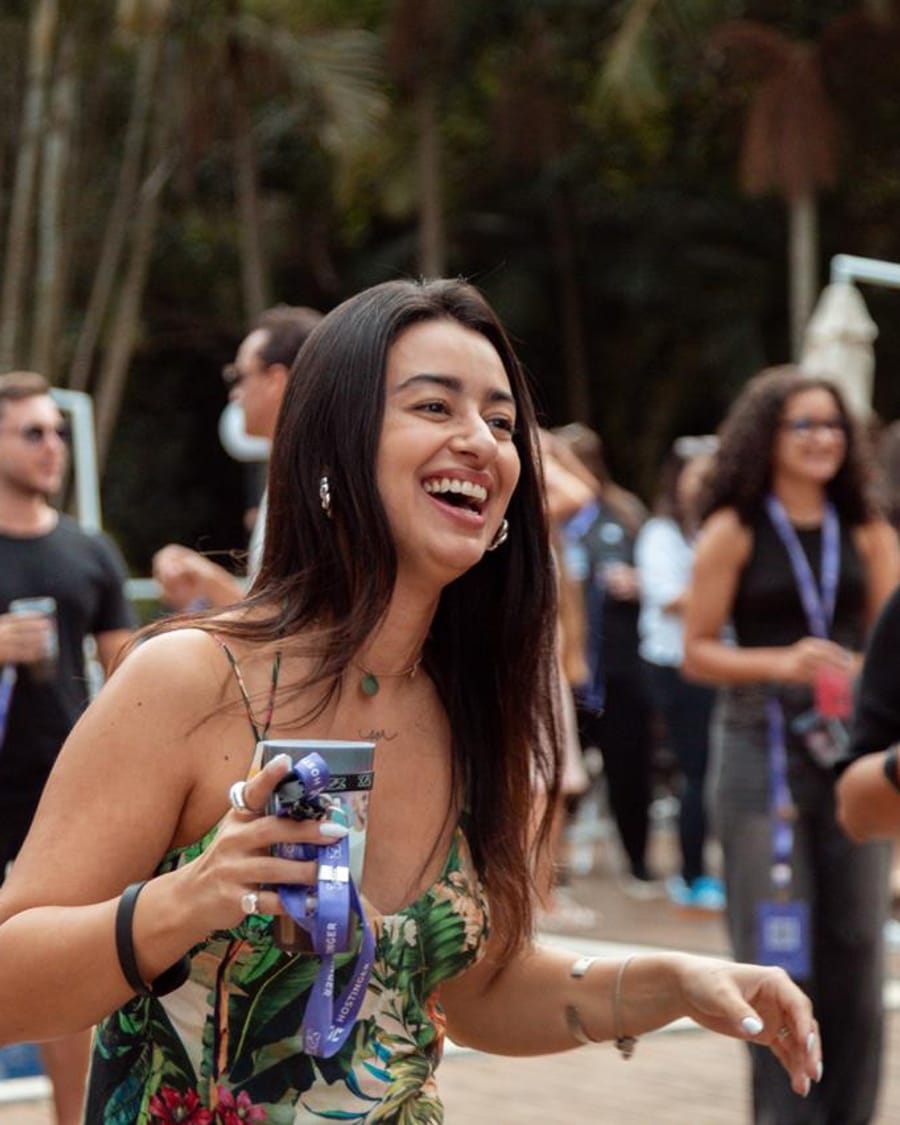 Guest laughing with a cup in hand by the pool